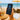 Hand holding a smartphone with a 'Guest Access Granted' message on a beach setting.