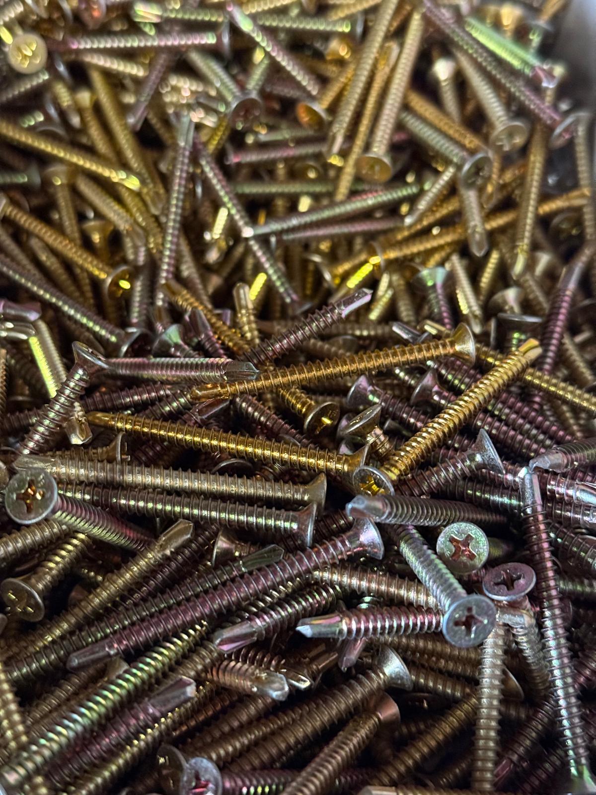 Close-up of a pile of self tapping screws with various colors.