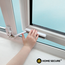 Child's hand operating a white sliding window restrictor lock on a UPVC frame, with a safety cable attached, light blue background, Home Secure logo in corner