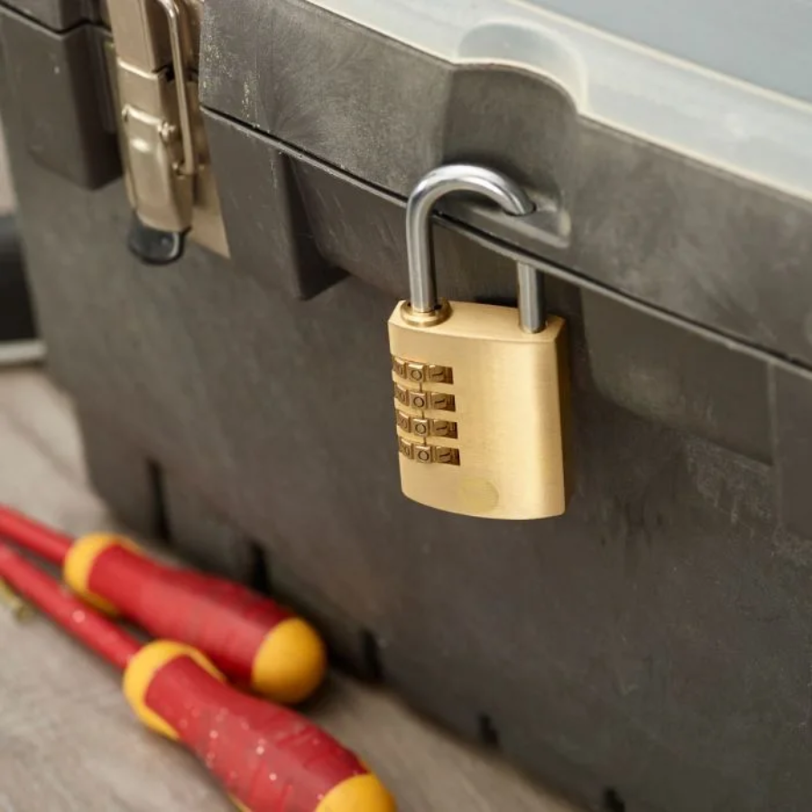 Yale 40mm brass combination padlock lock on a toolbox with tools in the foreground