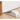White door stop wedge alarm placed on a wooden floor, positioned under a white door. The device features an on/off switch and is designed to prevent the door from opening while sounding an alarm if tampered with.