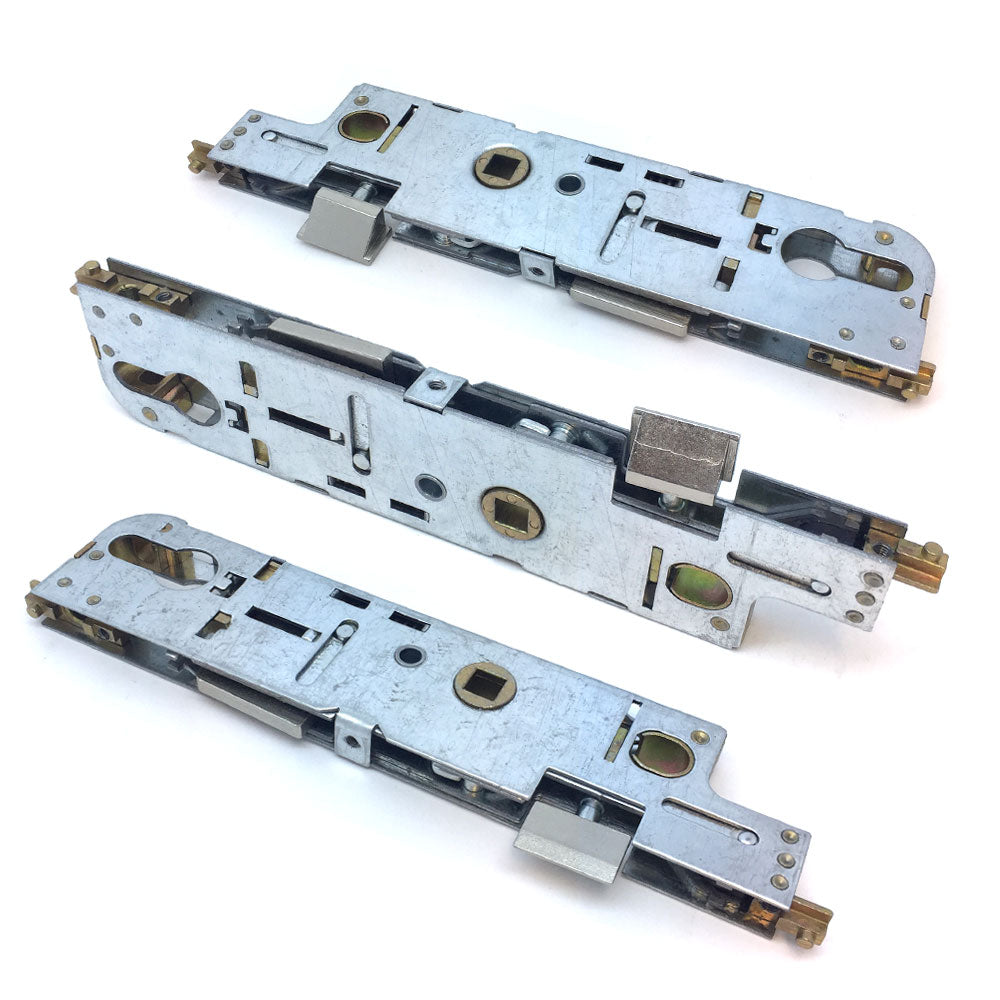 A set of metal door lock mechanisms displayed against a white background, including a central case and single spindle parts.