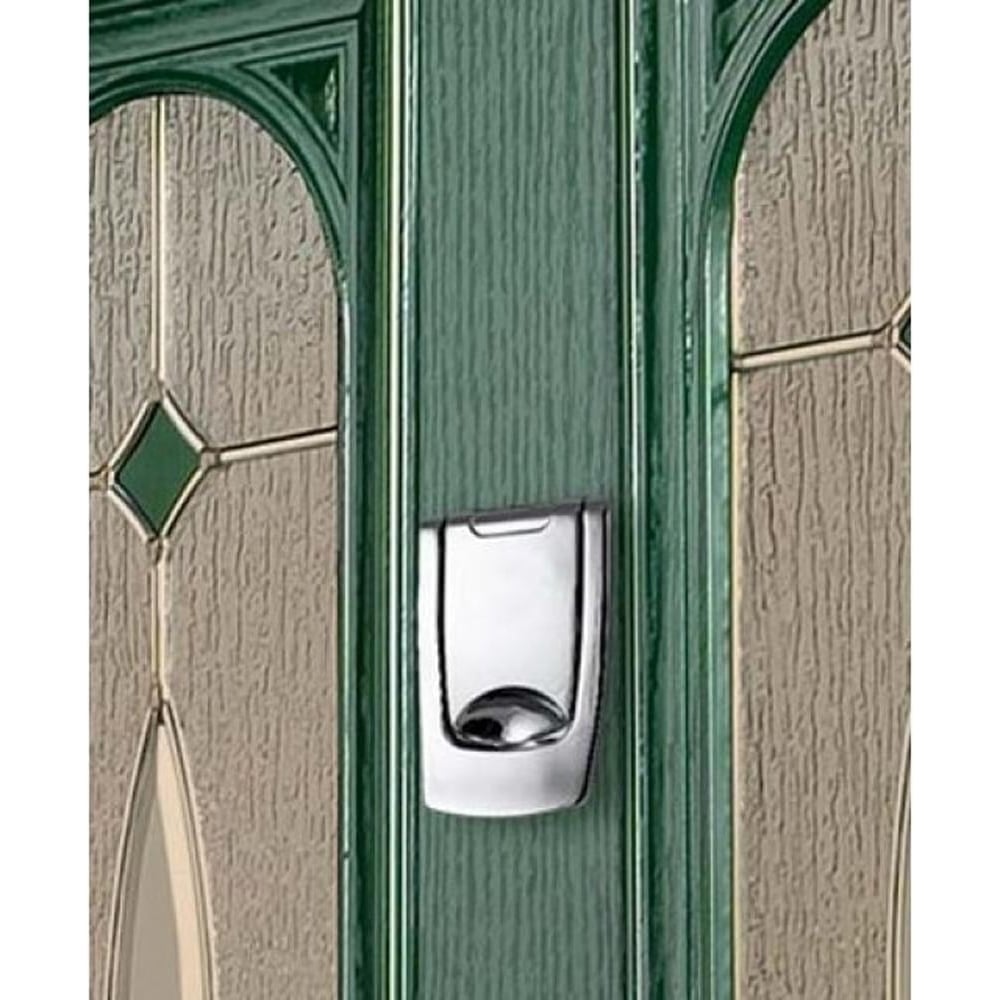 Polished chrome doorbell button mounted on a green door with decorative glass panels on either side.