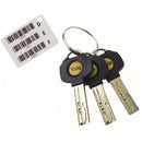 A set of three Yale dimple keys with black plastic heads attached to a metal keyring. Next to the keys is a white key code card labeled with the letters D, E, and F, each accompanied by a barcode and a numerical code beneath it.