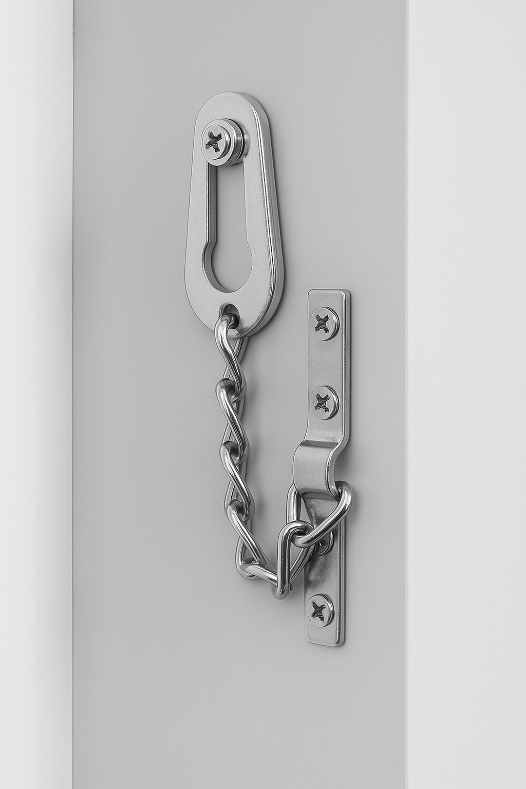 Metal door handle with door chain for upvc doors installed on a white background