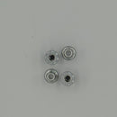Four metallic jack nuts on a grey background