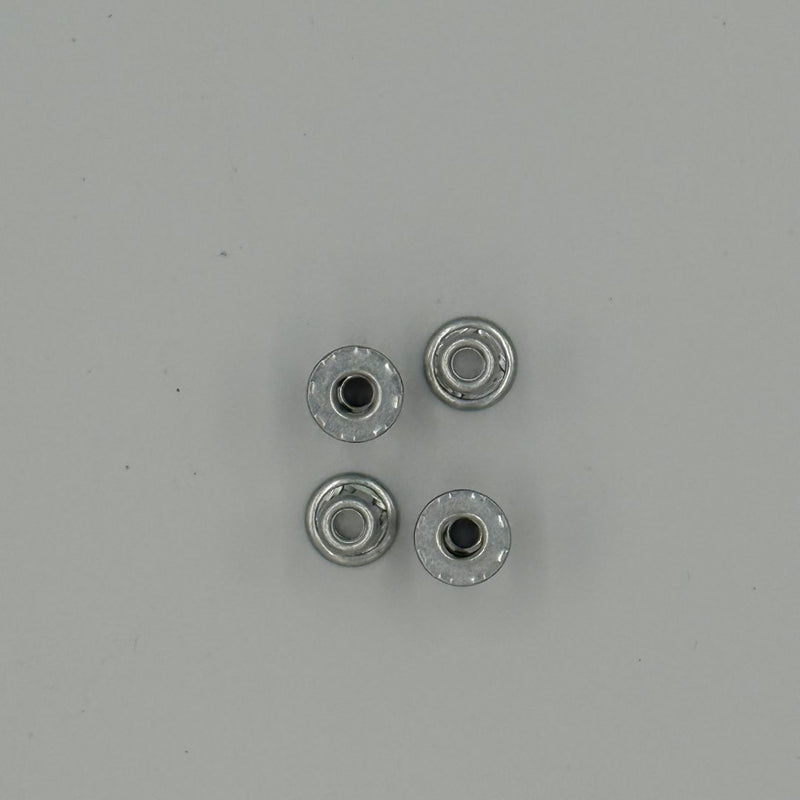 Four metallic jack nuts on a grey background