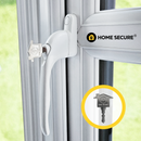 White replacement uPVC window handle with a key inserted in the lock, attached to a white window frame. The key features the Home Secure logo. The background shows greenery outside the window