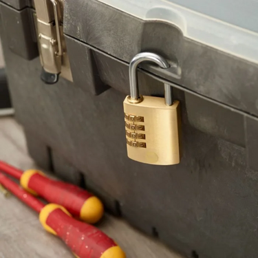Yale 40mm brass combination padlock lock on a toolbox with tools in the foreground