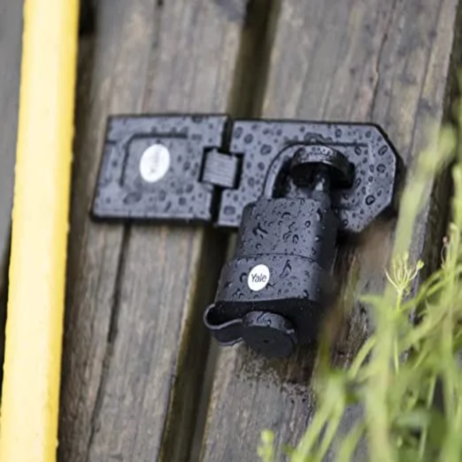 Yale 51mm padlock and hasp installed on a wooden gate for outdoor security and access control.