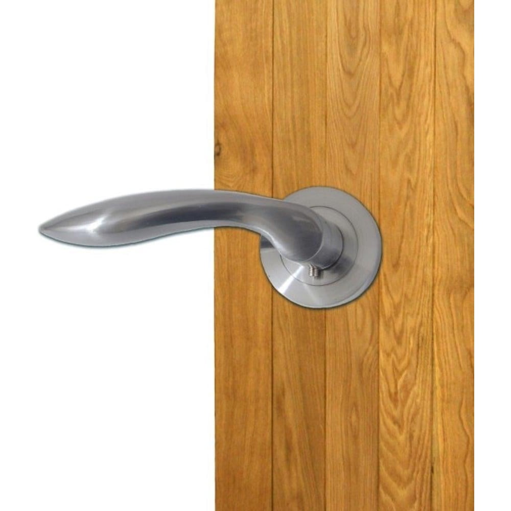 Curved satin chrome internal door handle mounted on a wooden door with round rose backplate.