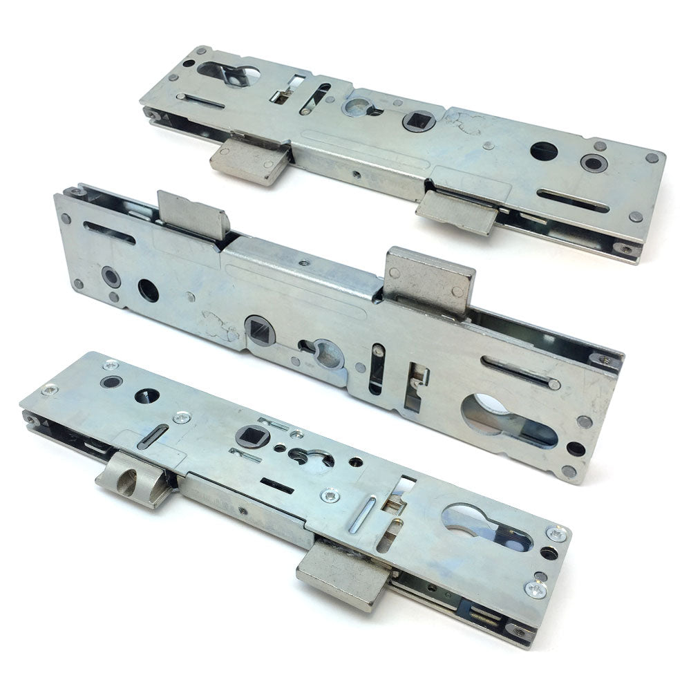 Metallic door lock center cases with gearboxes, displayed in a disassembled manner against a white background.